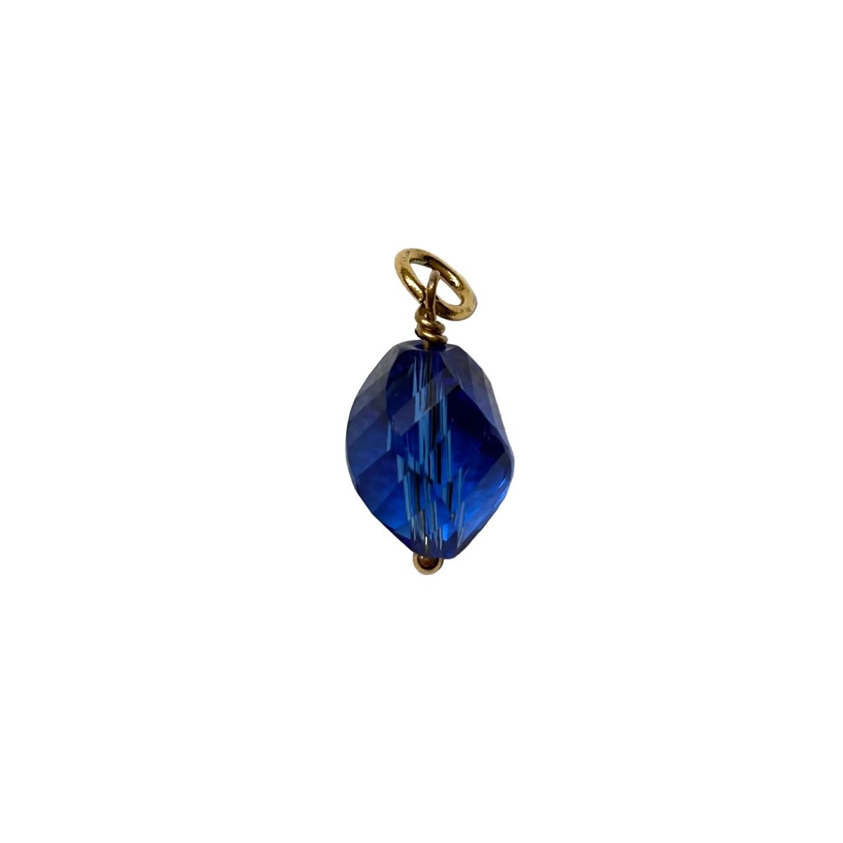 Blue glass pendant with gold chain on a white fabric background