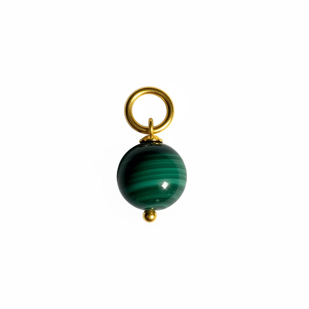 Green bead charm on a gold chain against a textured white background