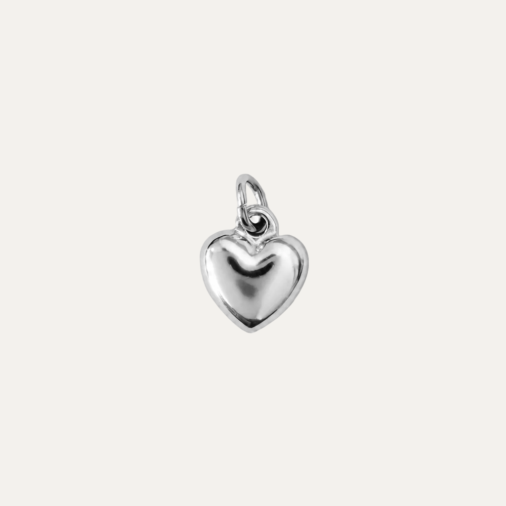 A polished silver heart-shaped charm with a smooth, reflective surface and a small top loop, centered on a plain white background.