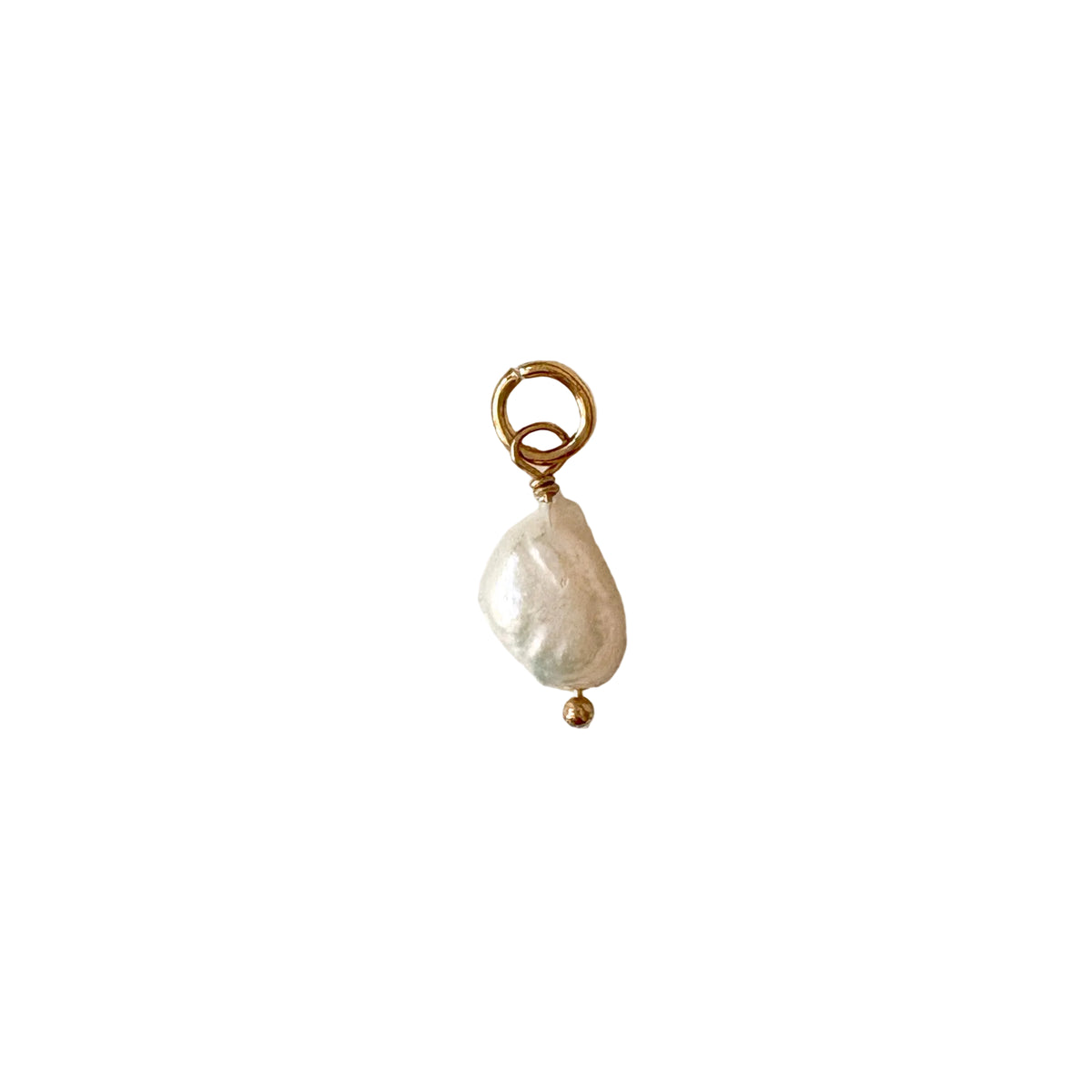 Pearl charm with gold accents on a textured white background