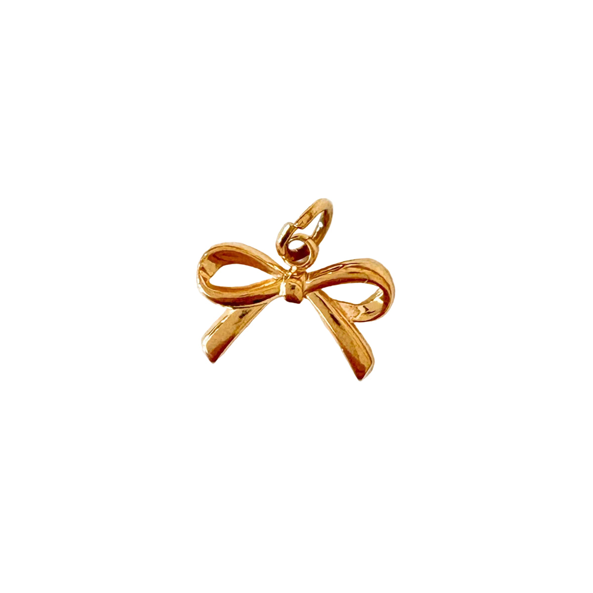 Gold bow-shaped pendant on a white textured background