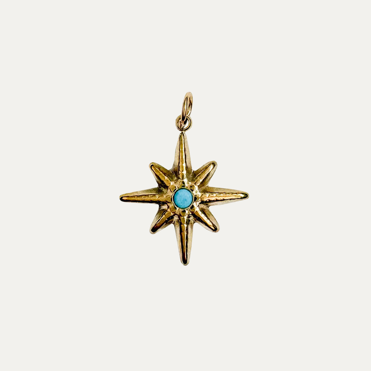 gold sparkling star with a turquoise stone in the middle