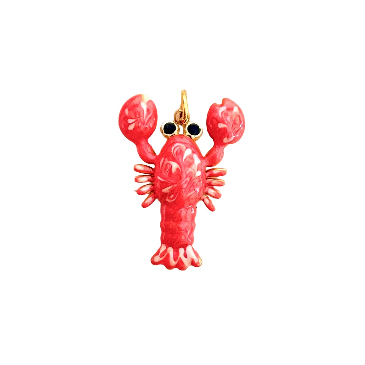 A lobster-shaped charm or pendant with a glossy pink-red enamel body, gold-tone metal outlines, and small black eye details, centered on a plain off-white background.