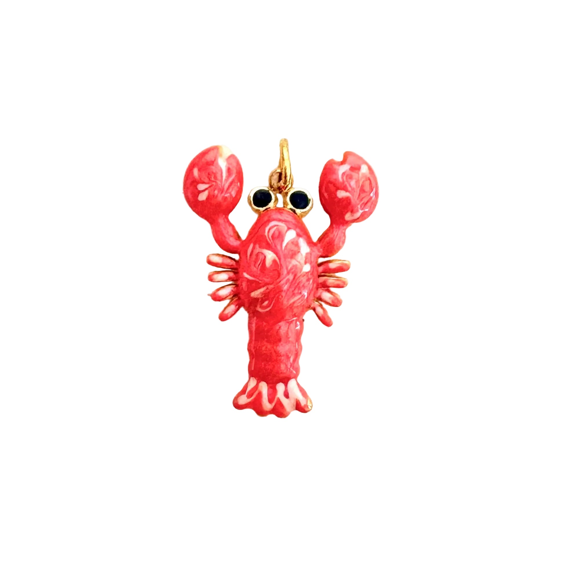 A lobster-shaped charm or pendant with a glossy pink-red enamel body, gold-tone metal outlines, and small black eye details, centered on a plain off-white background.